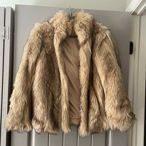 Hip length faux fur jacket. Interior toggle fastening.